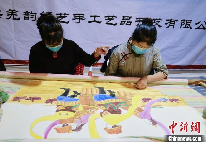 圖為皮繡藝人在市集上“秀”指尖技藝。　馬銘言 攝