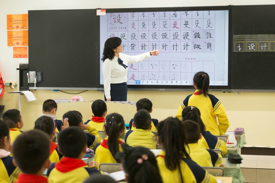民族路小學(xué)（迎賓校區(qū)），語文老師燕凌云與學(xué)生們共同評(píng)議同學(xué)書寫的漢字.jpg