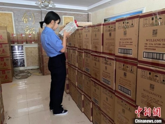 資料圖為檢察人員核對查獲的假冒品牌白酒。青海省人民檢察院供圖