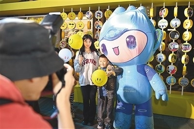 5月7日，在浙江省杭州市湖濱步行街“3D笑臉墻”前，攝影師為游客與杭州亞運會吉祥物之一“宸宸”拍攝合影。