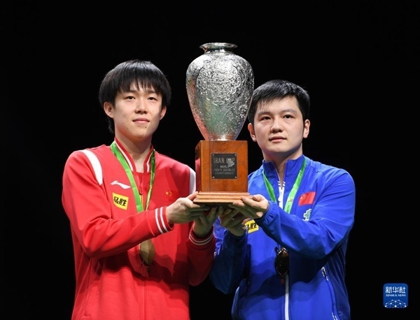 5月27日，樊振東（右）/王楚欽在頒獎儀式上高舉獎杯慶祝。當(dāng)日，在南非德班進(jìn)行的2023年世界乒乓球錦標(biāo)賽男雙決賽中，中國組合樊振東/王楚欽以3比0戰(zhàn)勝韓國組合張禹珍/林鐘勛，奪得冠軍。新華社記者 李亞輝攝