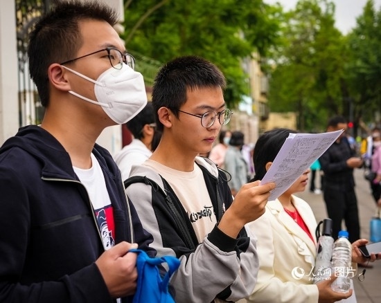 6月7日，在昆明市第五中學(xué)考場(chǎng)外，考生正利用最后時(shí)間復(fù)習(xí)備考。人民網(wǎng) 曾智慧攝