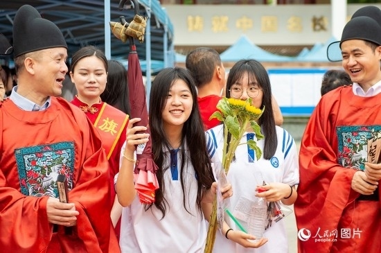 6月7日上午，在南寧市天桃實(shí)驗(yàn)學(xué)校翠竹校區(qū)，老師們?cè)跒榭忌鷤兗佑凸膭?！人民網(wǎng)記者 嚴(yán)立政攝