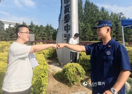 6月7日，遼寧營(yíng)口老邊區(qū)消防救援大隊(duì)的消防員為高考學(xué)子加油助威。人民網(wǎng)記者 尹柏寒?dāng)z