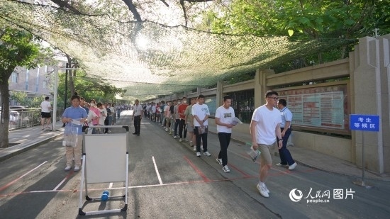 6月7日，烏魯木齊市第七十中學(xué)門口，考生們有序進(jìn)入考場(chǎng)。人民網(wǎng) 李欣洋攝