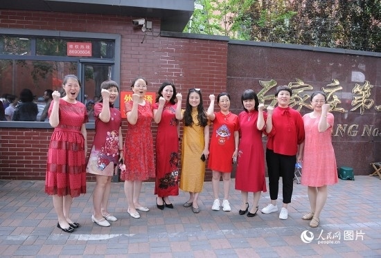 6月7日，在石家莊第二十七中學(xué)考點(diǎn)，家長(zhǎng)身著旗袍，為高考的孩子們加油助威！紅紅火火、旗開(kāi)得勝！人民網(wǎng)記者 周博攝