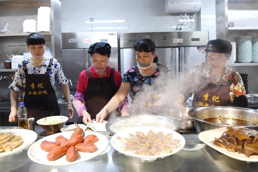 福建三明市沙縣區(qū)一家小吃店工作人員在為客人準(zhǔn)備特色小吃。 新華社記者 林善傳 攝