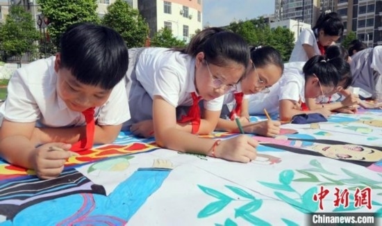圖為學生們用手中畫筆在進行創(chuàng)作。 興業(yè)縣融媒體中心供圖