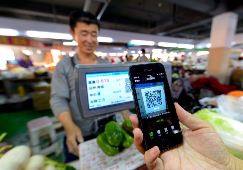 在河北省邯鄲市一家便民市場(chǎng)，消費(fèi)者在掃碼支付購買蔬菜（2018年6月3日攝）。新華社記者 王曉 攝