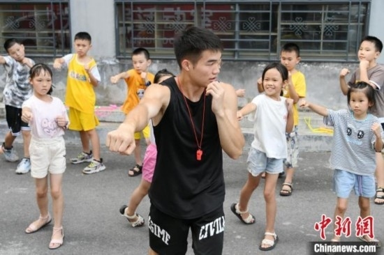 圖為大學(xué)生志愿者在組織孩子們參加體育健身活動(dòng)。廖光福 攝