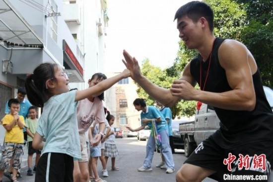 圖為大學(xué)生志愿者在組織孩子們參加體育健身活動(dòng)。廖光福 攝