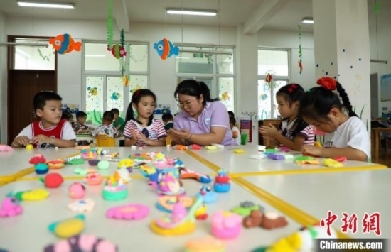 在肥西縣山南鎮(zhèn)中心幼兒園，孩子們?cè)诶蠋煹闹笇?dǎo)下做彩色泥塑。陳家樂 攝
