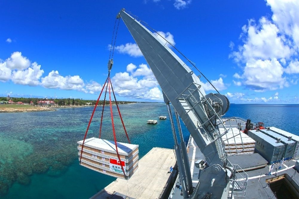 ↑赴湯加執(zhí)行運送救災(zāi)物資任務(wù)的中國海軍艦艇編隊在努庫阿洛法港卸載移動板房（2022年2月19日攝）。新華社發(fā)（薛成清 攝）