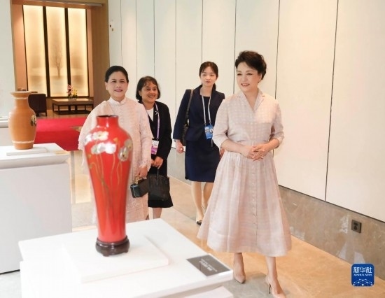 7月27日下午，國(guó)家主席習(xí)近平夫人彭麗媛在四川成都會(huì)見陪同印度尼西亞總統(tǒng)佐科來華出席第31屆世界大學(xué)生夏季運(yùn)動(dòng)會(huì)開幕式并訪華的總統(tǒng)夫人伊莉亞娜。這是彭麗媛和伊莉亞娜欣賞成都特色非遺工藝品。新華社記者 丁林 攝
