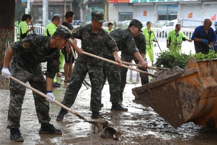 武警河北總隊保定支隊官兵在涿州市城西107國道沿線清理淤泥（8月5日攝）。新華社發(fā)（王紅強 攝）