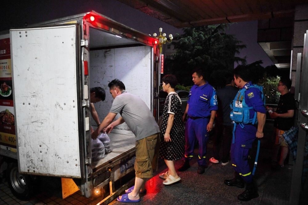 河北省涿州市職教中心安置點的工作人員在運送飯菜，準備發(fā)放給安置群眾（8月1日攝）。新華社記者 牟宇 攝