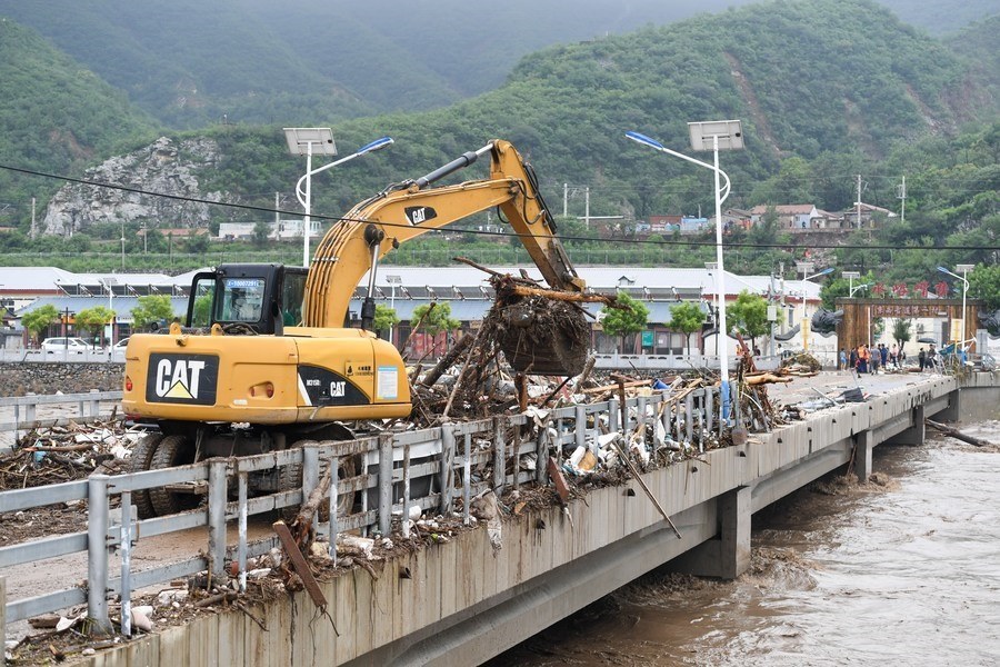 8月1日，在北京市門頭溝區(qū)水峪嘴村村口，一臺挖掘機在清理阻斷橋梁交通的雜物。目前該條道路已經(jīng)疏通完成。新華社記者 鞠煥宗 攝