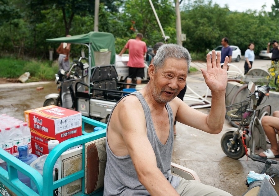 8月5日，從安置點回來的北京市房山區(qū)青龍湖鎮(zhèn)口頭村村民高大爺領到生活物資準備回家。新華社記者 張晨霖 攝