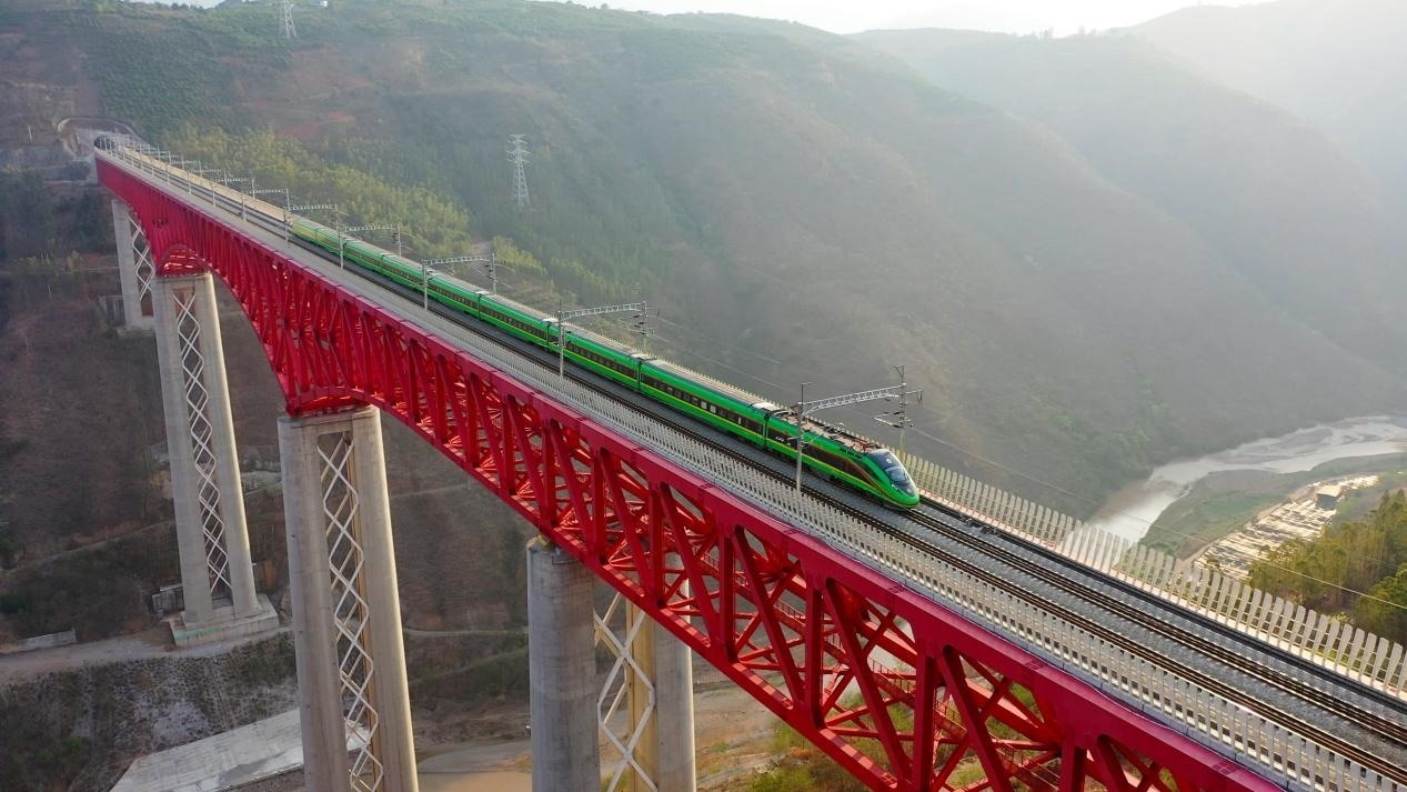中老鐵路國際旅客列車在云南省境內(nèi)的元江特大橋上飛馳。姚巍攝