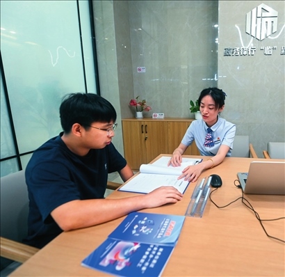 在杭州市臨安區(qū)政務(wù)服務(wù)中心的“為企服務(wù)中心”，黨員志愿者（右）解答企業(yè)主的疑問（2023年7月7日攝）。徐昱攝/本刊