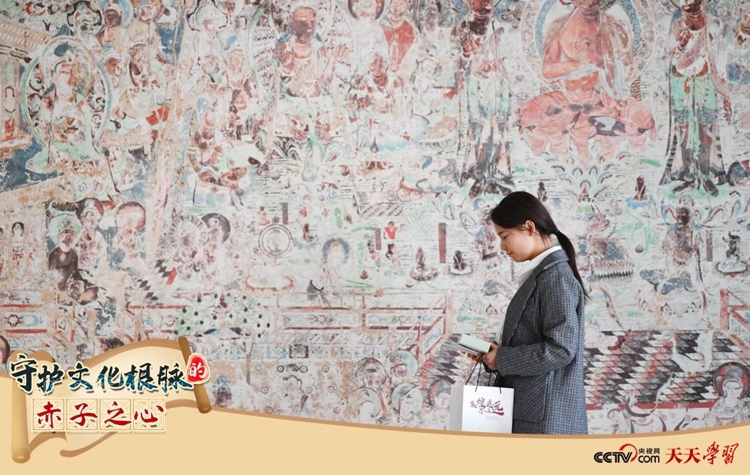 2023年4月25日，敦煌研究院文物數(shù)字化保護(hù)團(tuán)隊(duì)創(chuàng)意營(yíng)銷人員廖雪婷從一幅高保真復(fù)制壁畫前走過(guò)。