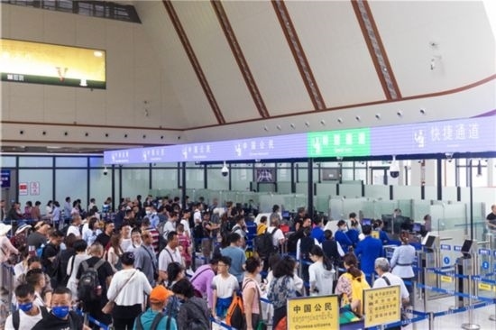 7月22日，乘坐中老鐵路國際旅客列車的旅客在磨憨邊檢大廳排隊(duì)候檢。衛(wèi)海林 攝