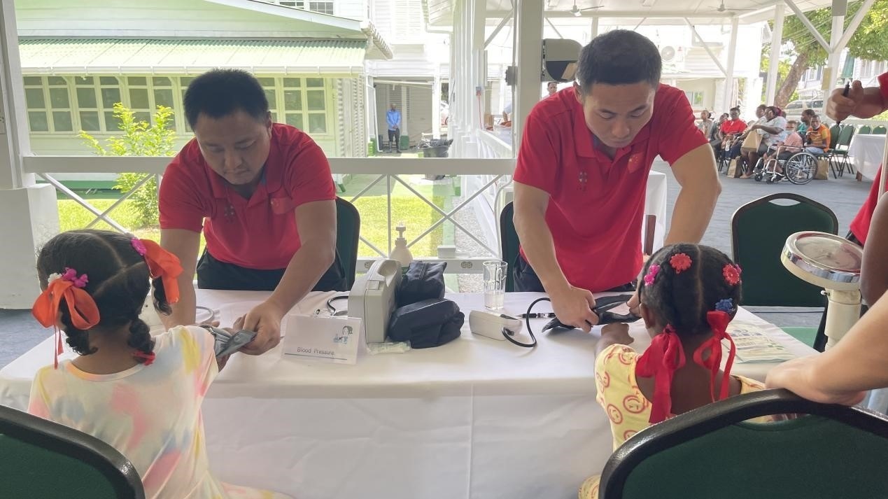 醫(yī)療隊(duì)員為福利院兒童進(jìn)行檢查。第18期援圭亞那醫(yī)療隊(duì)供圖