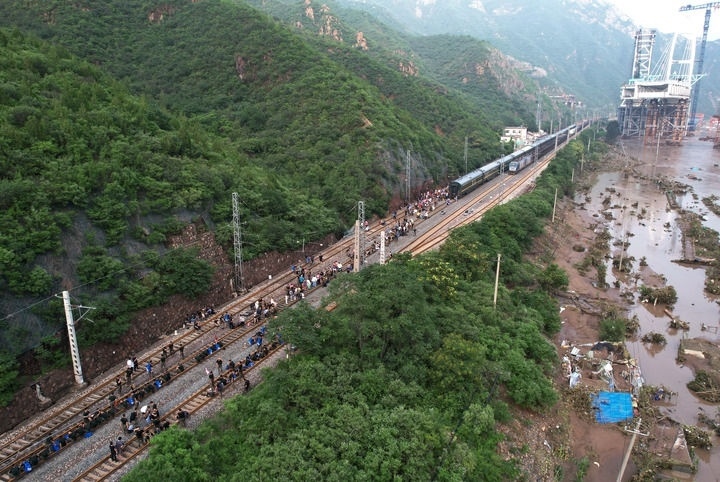 8月2日，受困列車旅客在救援人員幫助下徒步趕往轉(zhuǎn)運(yùn)客車（無(wú)人機(jī)照片）。新華社記者 張晨霖 攝