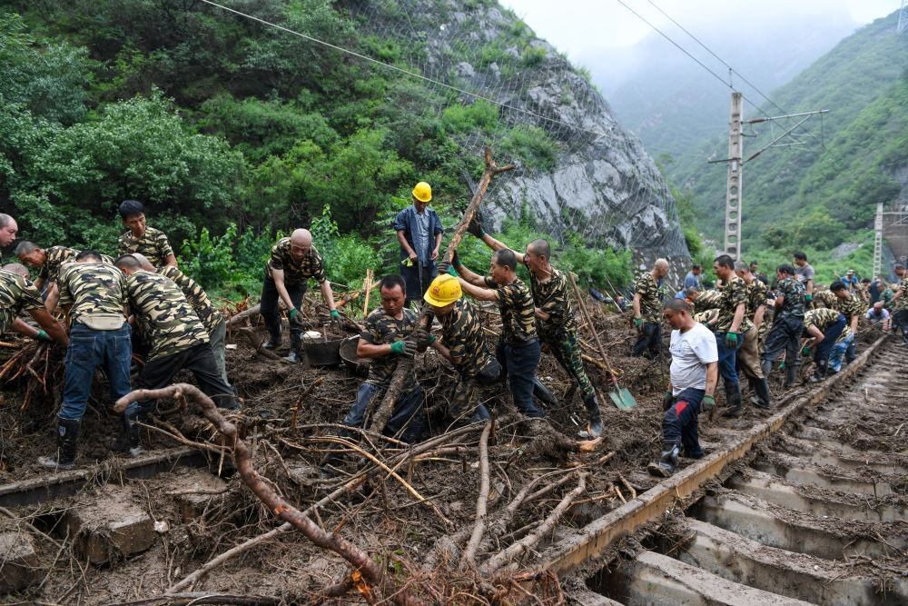 8月1日，在北京市門頭溝區(qū)水峪嘴村附近一段被阻斷的鐵路線上，中鐵六局工作人員在清理軌道上的雜物，全力恢復(fù)交通。新華社記者 鞠煥宗 攝