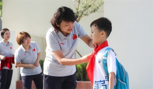 8月30日，雄安史家胡同小學(xué)學(xué)生體驗(yàn)學(xué)校生活。老師為學(xué)生佩戴校徽。