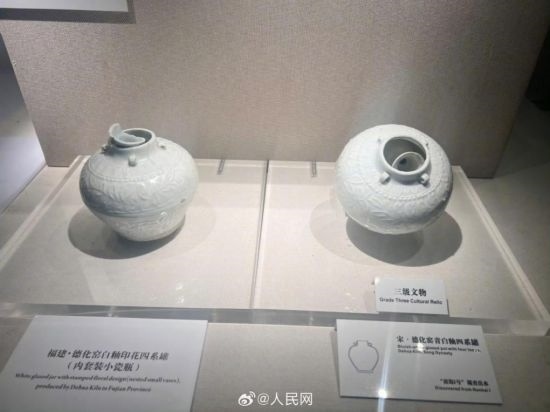 福建德化窯白釉印花四系罐（左）。人民網(wǎng)記者 李娜攝