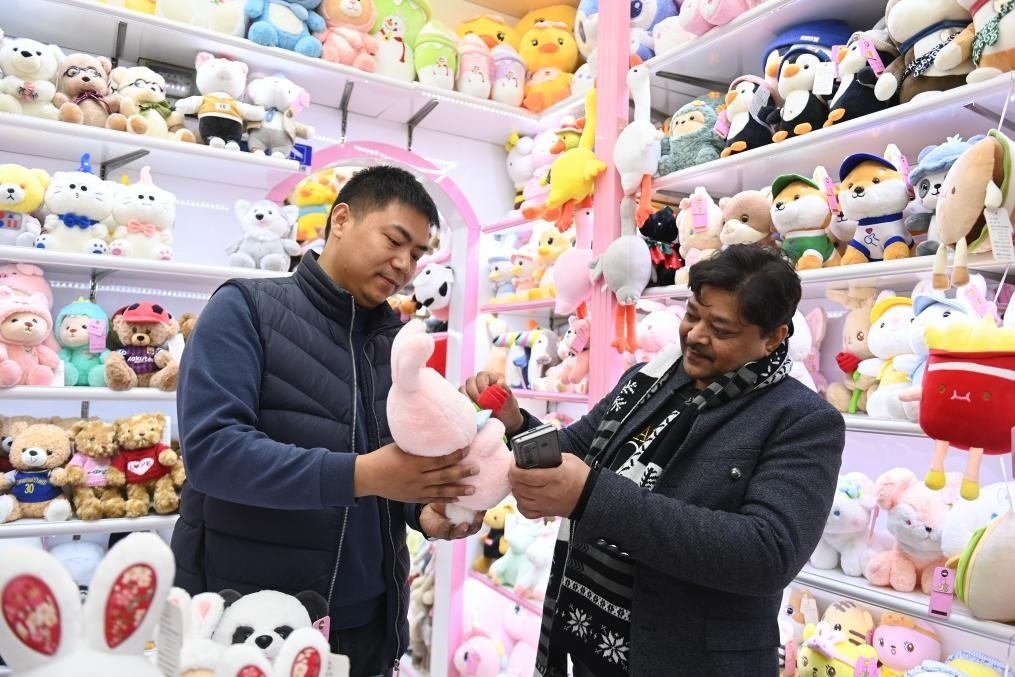 2023年2月2日，來自印度的客商（右）在義烏國際商貿(mào)城的一家玩具店鋪內(nèi)選購商品。新華社記者 黃宗治 攝