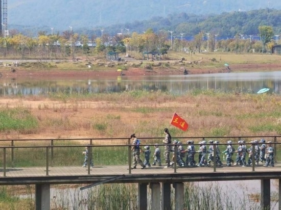 10月24日，秋游的幼兒園小朋友在老師帶領(lǐng)下走在清水塘公園里的木橋上。本報(bào)記者 常雯宜攝