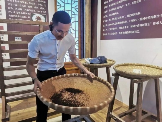 2023“一帶一路”媒體合作論壇聯(lián)合采訪團(tuán)團(tuán)員在非遺文化展示館體驗(yàn)中藥炮制技藝。（本報(bào)記者 黃超攝）