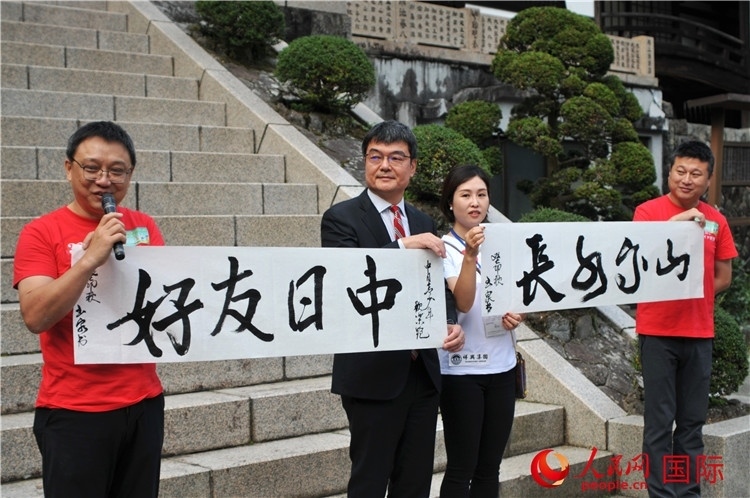 東京中國文化中心主任羅玉泉展示其為本次活動(dòng)書寫的題詞“中日友好，山高水長”。人民網(wǎng) 蔣曉辰攝