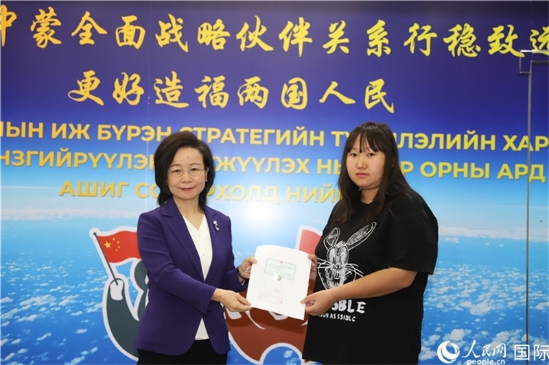 11月10日，沈敏娟大使向蒙古國(guó)公民尼亞姆庫(kù)（右）頒發(fā)最后一份領(lǐng)事認(rèn)證書。人民網(wǎng)記者 霍文攝