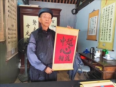 越南首都河內(nèi)文廟內(nèi)，阮明珠展示“中越心相近”書法作品。