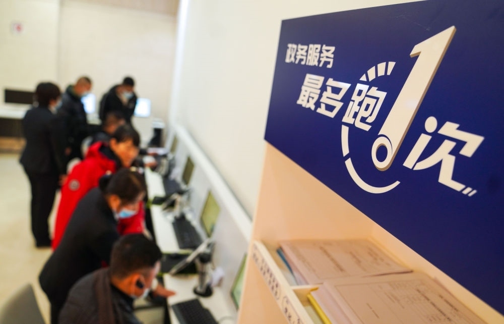 在吉林省長春市二道區(qū)政務(wù)服務(wù)中心輔助填報(bào)區(qū)，市民在工作人員的輔助下進(jìn)行事項(xiàng)填報(bào)（2020年11月23日攝）。新華社記者 許暢 攝