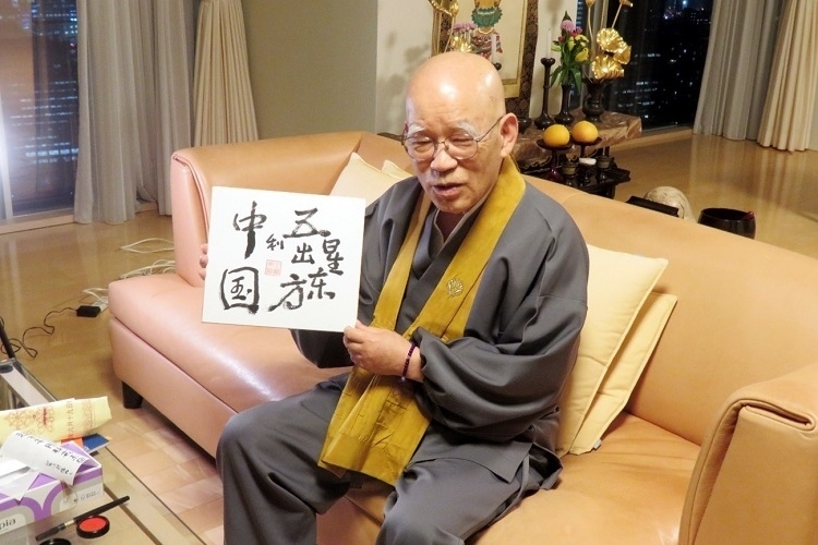 小島康譽展示自己書寫的“五星出東方利中國”。視頻截圖