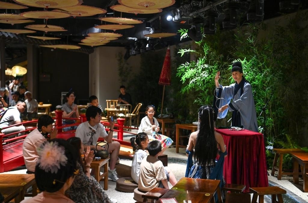 游客在長安十二時辰主題街區(qū)觀看唐風演藝《大唐曲藝》。新華社記者鄒競一 攝