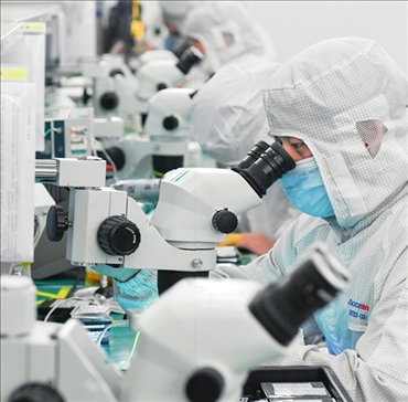 在位于武漢中國光谷的光電器件研發(fā)制造商——武漢光迅科技股份有限公司生產(chǎn)車間內(nèi)，技術(shù)人員在光模塊生產(chǎn)線作業(yè)（2023年4月11日攝）。程敏攝/本刊