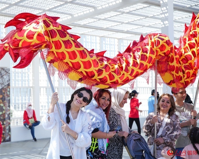 游客體驗舞龍。 人民網(wǎng) 塔里克·易卜拉欣攝