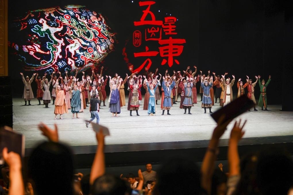 2023年7月31日，新疆和田地區(qū)新玉歌舞團(tuán)在烏魯木齊京劇院演出舞劇《五星出東方》后和觀眾互相揮手致意。這場(chǎng)演出是第六屆中國(guó)新疆國(guó)際民族舞蹈節(jié)的參演劇目之一，曾榮獲國(guó)家“文華獎(jiǎng)”等。新華社記者 郝昭 攝