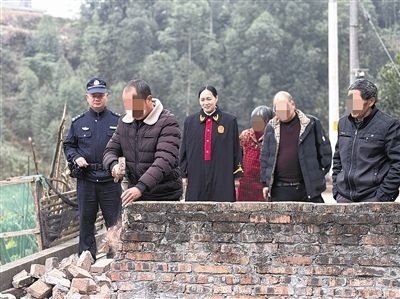  圖③：庭審結(jié)束后，在法官的見(jiàn)證下，陳某在院壩邊重新開(kāi)鑿一條通道。