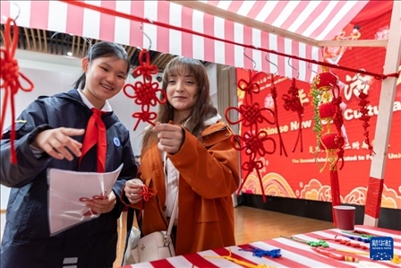 1月28日，復(fù)旦大學(xué)第二附屬學(xué)校學(xué)生（左）為美國馬斯卡廷中學(xué)學(xué)生（右）介紹中國結(jié)。 新華社記者 王翔 攝