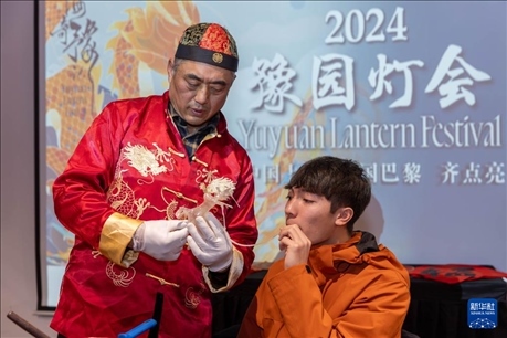 1月28日，在上海豫園舉行的民俗活動上，美國馬斯卡廷中學(xué)學(xué)生在非遺傳承人的指導(dǎo)下吹糖偶。 新華社記者 王翔 攝