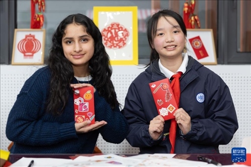 1月28日，美國馬斯卡廷中學(xué)學(xué)生（左）和復(fù)旦大學(xué)第二附屬學(xué)校學(xué)生展示互相送出的寫有寄語祝福的紅包。 新華社記者 王翔 攝