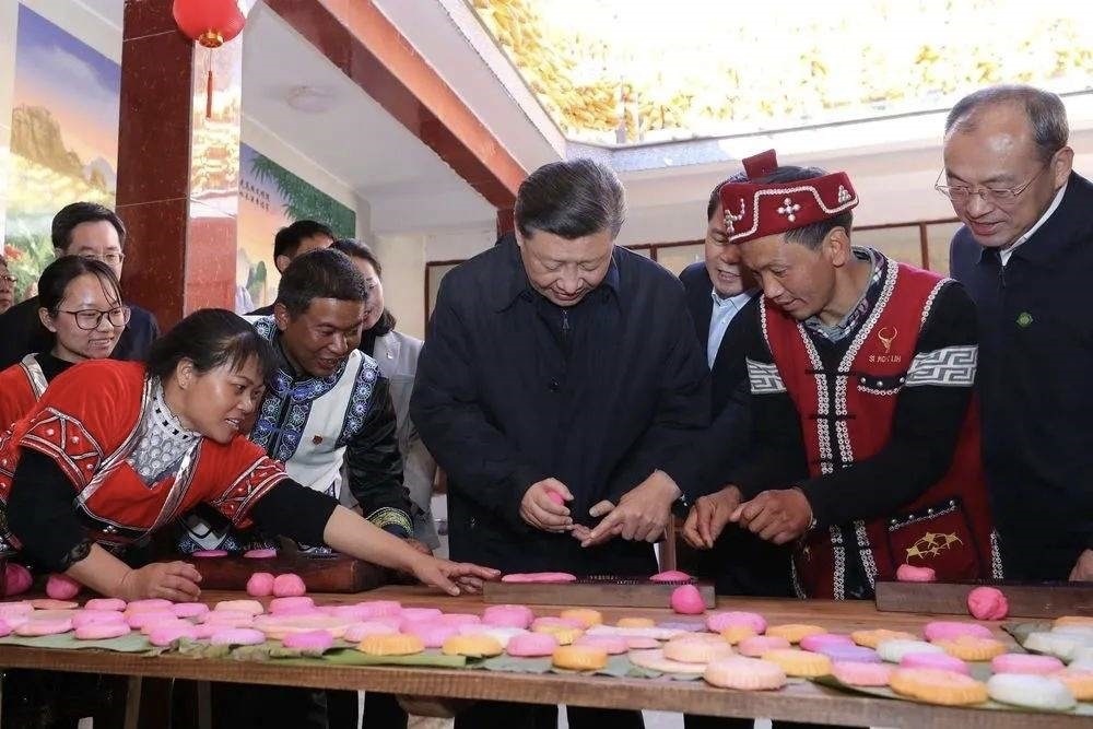 2020年1月19日，習(xí)近平總書(shū)記在云南省騰沖市清水鄉(xiāng)三家村中寨司莫拉佤族村，同村民李發(fā)順一家制作當(dāng)?shù)毓?jié)日傳統(tǒng)食品大米粑粑。新華社記者 鞠鵬 攝