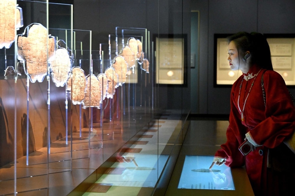 2月26日，參觀(guān)者在河南安陽(yáng)殷墟博物館新館內(nèi)觀(guān)看展出的刻辭卜甲。