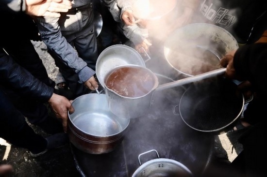  2月27日，在加沙地帶北部的杰巴利耶難民營(yíng)，人們領(lǐng)取食物。新華社發(fā)（穆罕默德·阿里攝）
